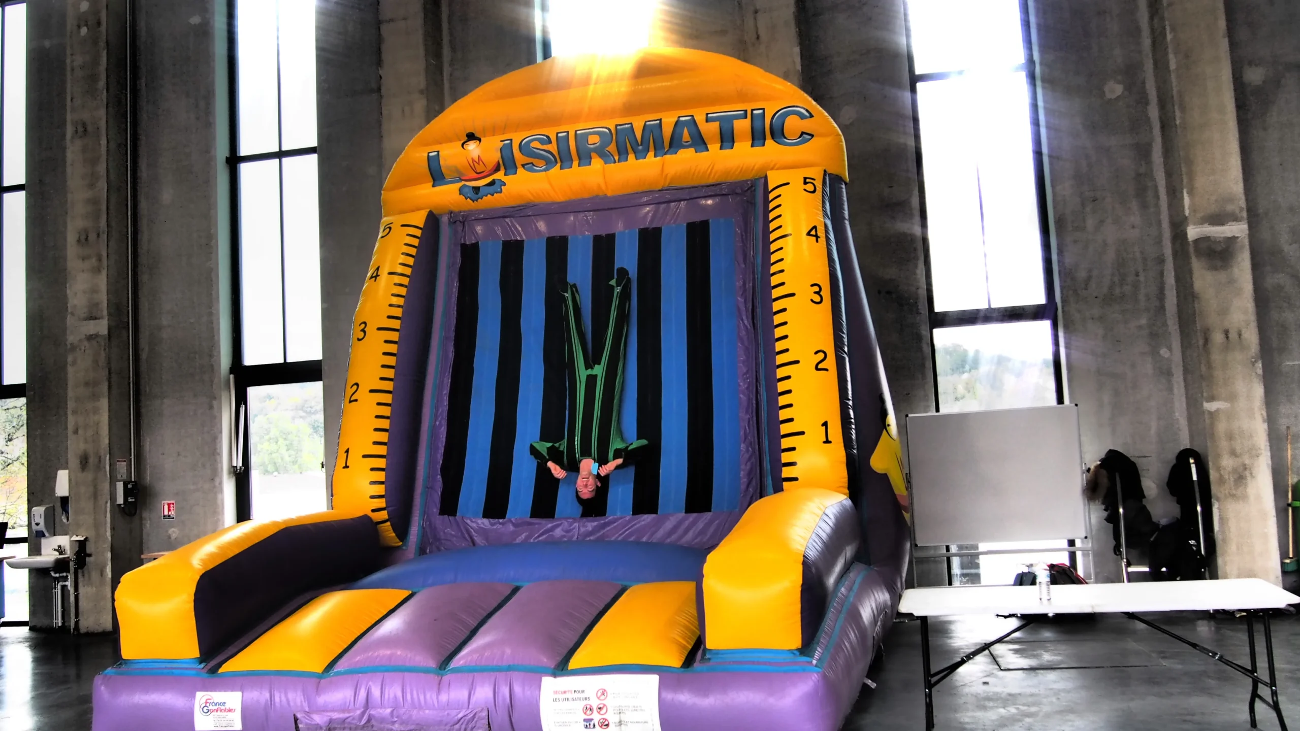 Surf simulator Montreal participant on the wave with a timekeeper officiating · INNOV'events