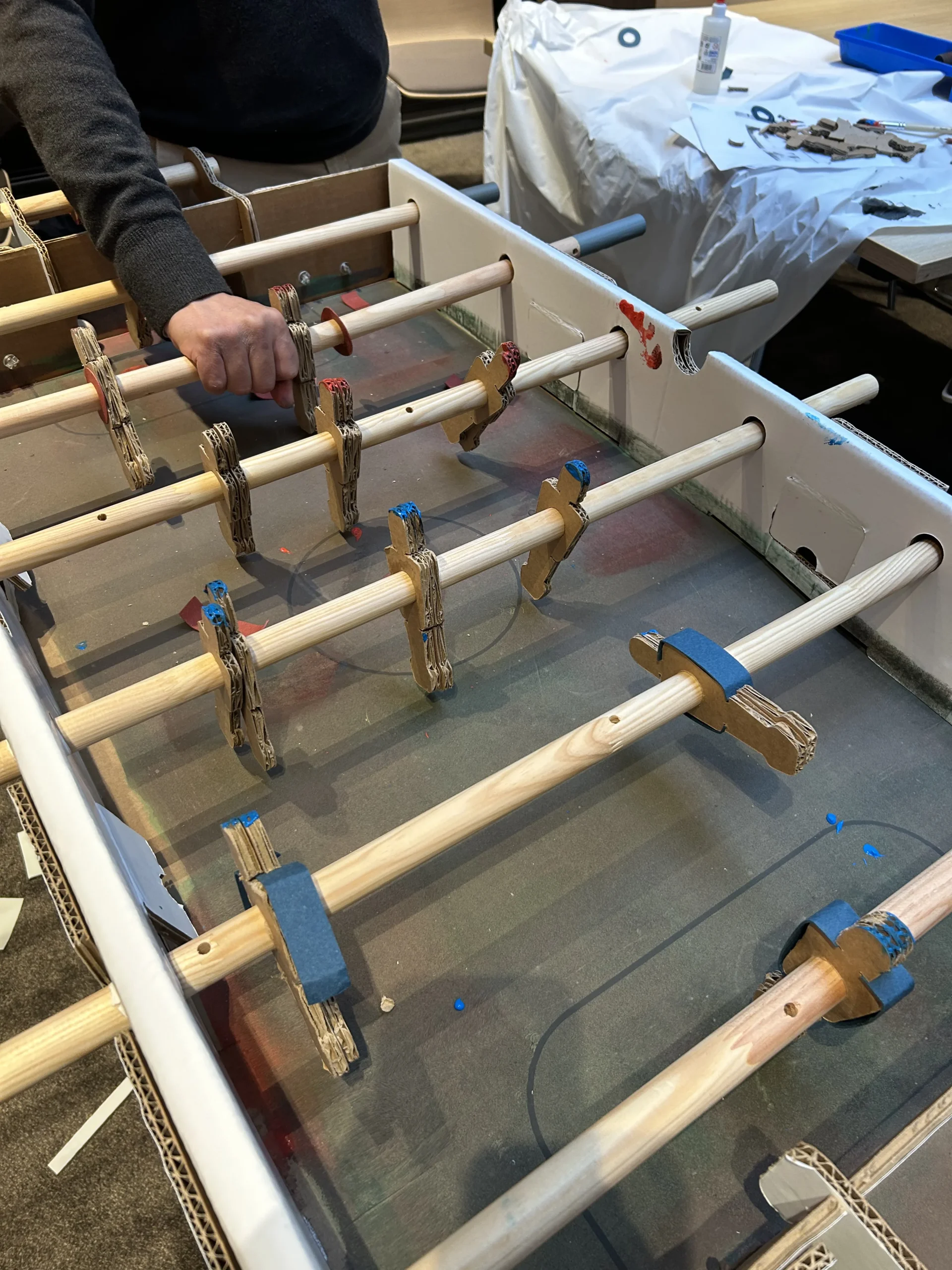 Foosball build Laval teams assembling their table in a bright event room · INNOV'events